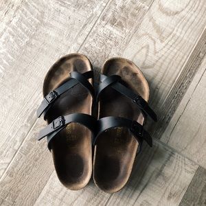 Black Birkenstock sandals with toe strap